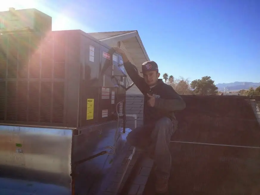HVAC technician performing AC Tune-Up on a rooftop unit in Princeton